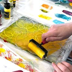 a person is painting on a tray with yellow and red colors in the process of making art