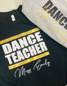 Treat your favorite DANCE TEACHER to our personalized Dance Teacher luxe cotton t-shirt. This long sleeve t-shirt comes in a variety of colors and printed with DANCE TEACHER on the front and your studio name or dance teacher name below.  Our super soft luxe cotton t-shirt is made of 100% cotton. Available in white, black, and navy with DANCE TEACHER printed in between 2 metallic gold lines and perfectly personalized with the name of your choice. Machine Wash Cold - Tumble Dry Low Please no retur Dance Studio Shirts Design, Dance Teacher Shirts Design, Dance Teacher Shirt, Black Pre-shrunk T-shirt For Dance Class, Cotton T-shirt With Letter Print For Dance Class, Hip Hop Letter Print T-shirt For Dance Class, Hip Hop T-shirt With Letter Print For Dance Class, Crew Neck T-shirt With Text Print For Dance Class, Cotton Hip Hop T-shirt For Dance Class