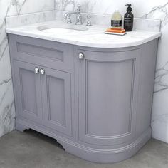 a bathroom vanity with marble top and two sinks in grey color, next to a white tiled wall