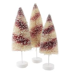 three small christmas trees on white bases with red and white frosting, set against a white background