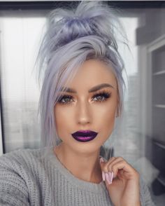 a woman with grey hair and purple lipstick