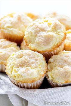 a plate full of lemon muffins on top of a white cloth covered table