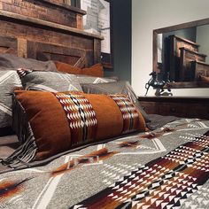 a bed with two pillows on top of it next to a wooden headboard and dresser