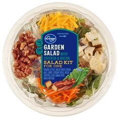 a salad with chicken, bacon, lettuce and carrots in a plastic container