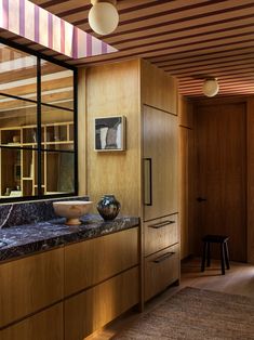 a kitchen with wooden cabinets and marble counter tops