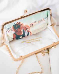 a purse that is sitting on top of a white cloth bag with a chain attached to it