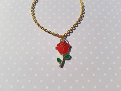 "this classy red rose bracelet would be a lovely gift for someone special! this delicate charm bracelet is made using a gold plated enamel pendant hung from gold plated chain.  total length of chain measures approx. 7\" and fastens with a lobster clasp fastener.  rose charm measures approx. 23mm x 13mm" Gold Flower Bracelets With Rose Design, Gold Floral Bracelets With Rose Design, Gold Flower Bracelet With Rose Design, Rose Gold Bracelet With Rose Design For Gift, Rose Bracelets For Valentine's Day, Rose Colored Bracelets For Valentine's Day Gift, Rose Color Bracelets For Valentine's Day, Gold Bracelet With Rose Design For Gift, Valentine's Day Gift Bracelet With Rose Design