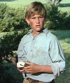 a young boy is holding a piece of food