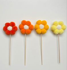 four different colored flower shaped lollipops sitting on top of each other in the same row