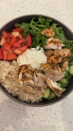 a bowl filled with rice, meat and veggies on top of a table