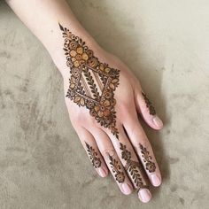 a woman's hand with henna tattoos on it