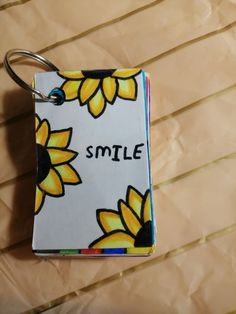 a small book with sunflowers on it and the word smile written in black