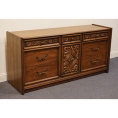 an ornately carved wooden sideboard with four drawers and two doors on the front