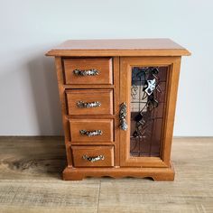 a wooden cabinet with many drawers and knobs on the doors is sitting on a wood floor