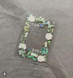 a glass plate with flowers on it sitting on a tablecloth covered surface in the shape of a letter e