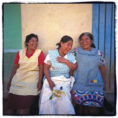 three women sitting next to each other smiling