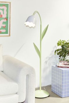 a white couch sitting next to a green plant in a living room