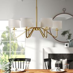 a chandelier hanging over a dining room table in front of a large window