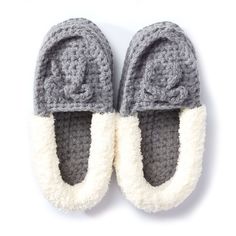 a pair of crocheted slippers with white and gray trims on top