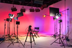 several lights are set up in front of a pink wall