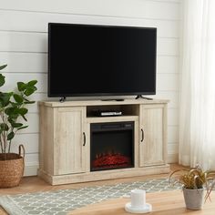 a living room with a fireplace and television on the entertainment center in front of it