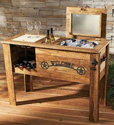 a wooden table with an ice chest and wine glasses