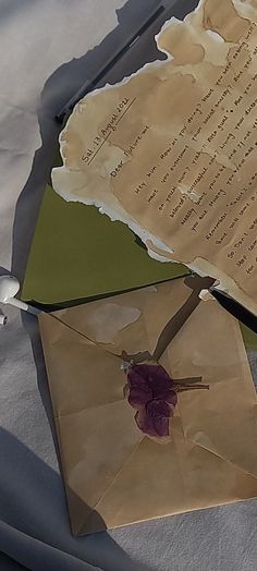 an open envelope with a rose on it next to a piece of paper that has been torn off