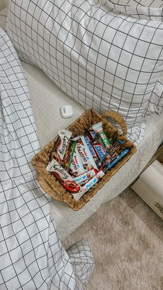 a basket filled with snacks sitting on top of a bed