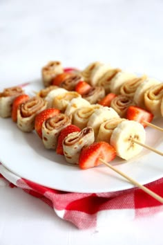 some food is sitting on a white plate and has strawberries in the shape of pretzels