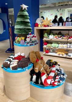 stuffed animals and other toys are on display at the store's christmas tree stand