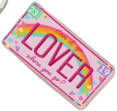 a keychain with the word love on it and a rainbow in the background