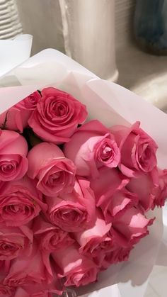 a bouquet of pink roses sitting on top of a table