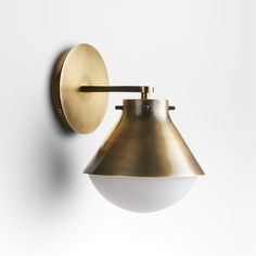 an antique brass wall light on a white wall