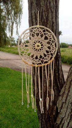 a white dream catcher hanging from a tree