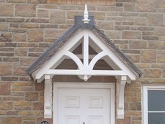 a white door and window in front of a brick building with an arch above it