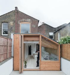 a person standing in the doorway of a house with an open door on it's side