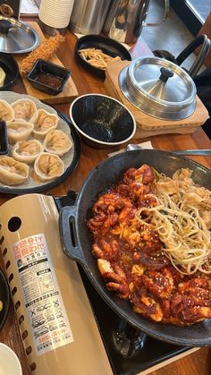 a table topped with lots of different types of food on top of plates and pans