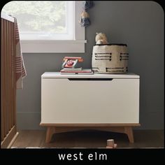 a white dresser sitting next to a window in a room with a stuffed animal on top of it