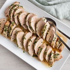 sliced chicken on a white plate with a spoon