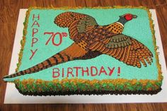 a birthday cake with an image of a pheasant on the side and words happy 70th