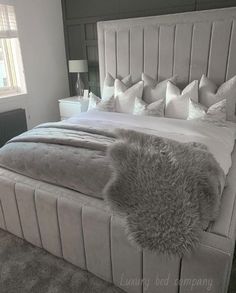 a large bed with white sheets and pillows on it's headboard in a bedroom