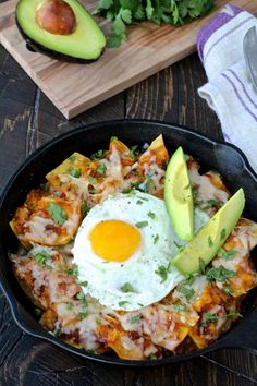 an egg is on top of some food in a skillet with avocado