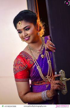 a woman in a purple and red sari holding onto a door with her hands