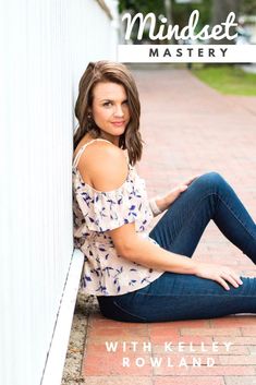 a woman sitting on the ground with her legs crossed