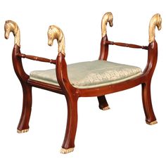 a wooden chair with two rams on it's back legs and seat padding