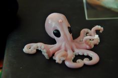 an octopus figurine sitting on top of a table next to a framed photo