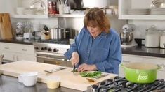 a woman cutting up vegetables on top of a kitchen counter