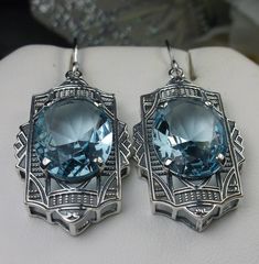 "Simulated Aquamarine Earrings Braid Design#E19 Custom Made Inspired by the Art Deco movement of the early 1900s, I now offer these lovely Antique reproduction earrings in sterling silver. Each stunning 8ct flawless Simulated Blue aquamarine is 16mm long (just over 5/8th\") and 12mm in width (1/2\"). The aquamarines have perfect color and clarity. The earrings are 1 3/4th inches long. Notice the beautiful design of the Deco filigree setting. These earrings were fashioned from an Art Deco 1930s b Art Deco Formal Earrings Hallmarked, Oval Art Deco Earrings For Formal Occasions, Art Deco Oval Earrings For Formal Occasions, Art Deco Hallmarked Drop Earrings, Formal Oval Art Deco Earrings, Hallmarked Art Deco Earrings For Anniversary, Art Deco Sterling Silver Earrings For Formal Occasions, Blue Elegant Earrings, Silver Art Nouveau Jewelry For Evening