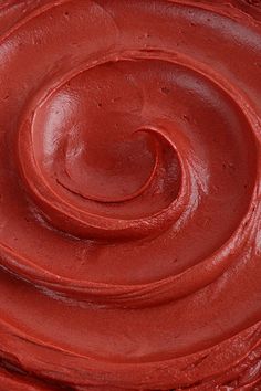 a close up view of a cake with red frosting on it's icing