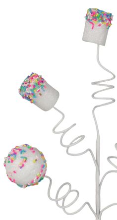 three donuts with sprinkles are on a wire